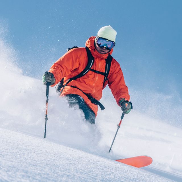 man in orange jackets skiing