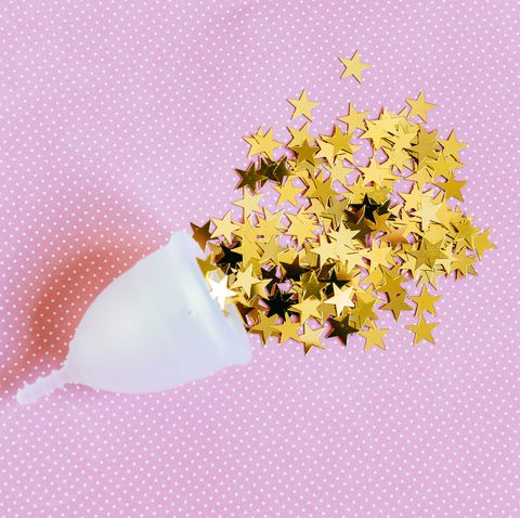 Menstrual cup with bright stars on pink background