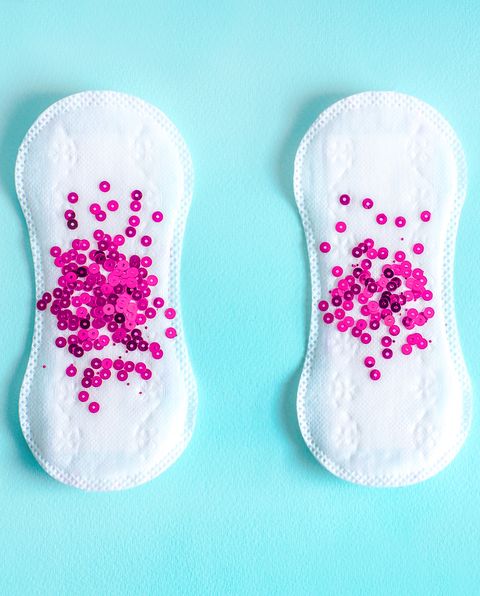 Menstrual pads with red glitter on colored background
