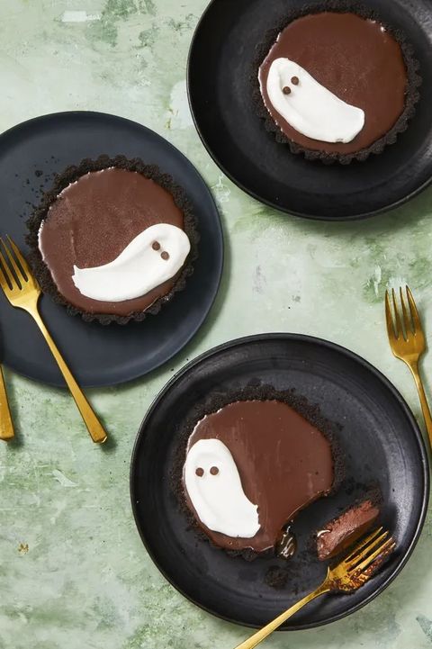 chocolate meringue tarts with white ghosts painted on them