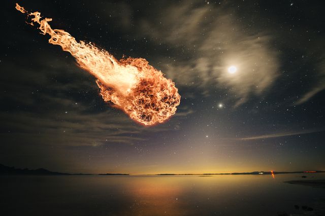 interstellar meteor falling through starry night sky over water
