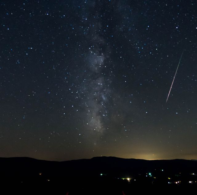 meteor shower shooting through the milky way and stars