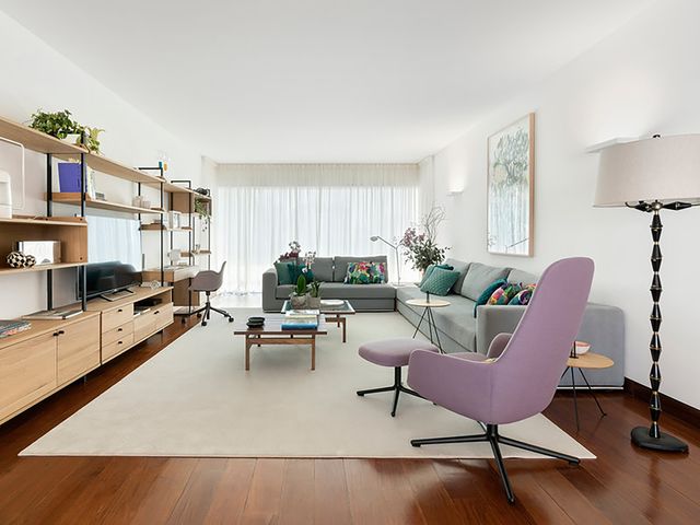 apartamento en lisboa de diseño   salón con sofá, escritorio y butaca con reposapiés como rincón de lectura
