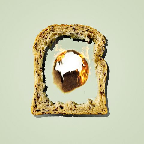 a piece of bread with th middle missing and a burning hole in the background behind it
