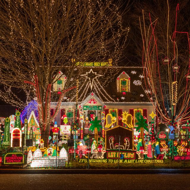 house overwhelmed by christmas light displays over it and in the yard