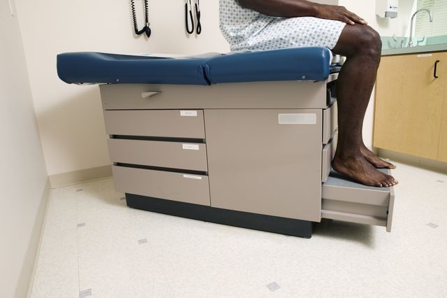 mid adult man sitting on an examination table in a doctor's office