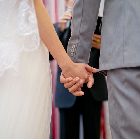 Midsection Of Couple Holding Hands During Wedding