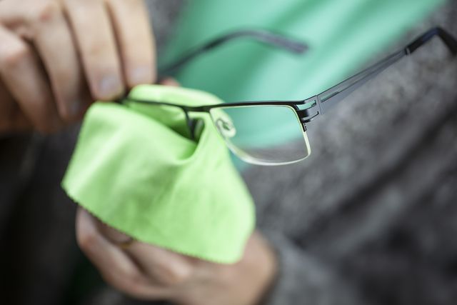 midsection of man cleaning eyeglasses