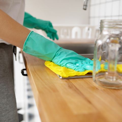 Midsection Of Woman Cleaning Kitchen Counter At Home
