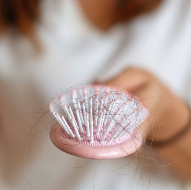 midsection of woman hairbrush with fallen hair