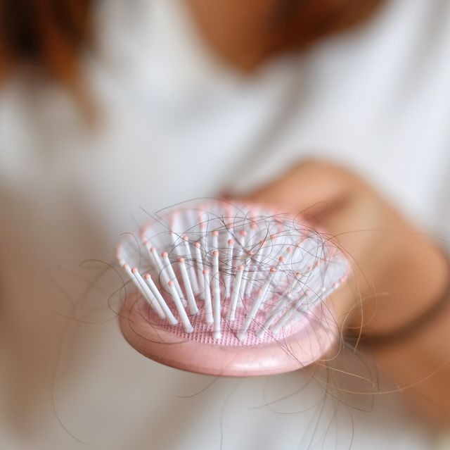 midsection of woman hairbrush with fallen hair