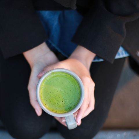 a cup of brewed hot matcha tea, which can help boost your holistic health over time