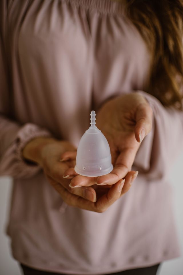 midsection of woman holding menstrual cup