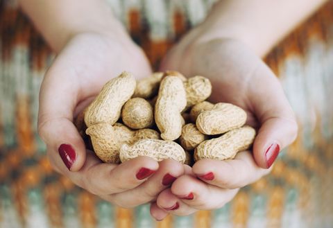 Midsection Of Woman Holding Peanuts