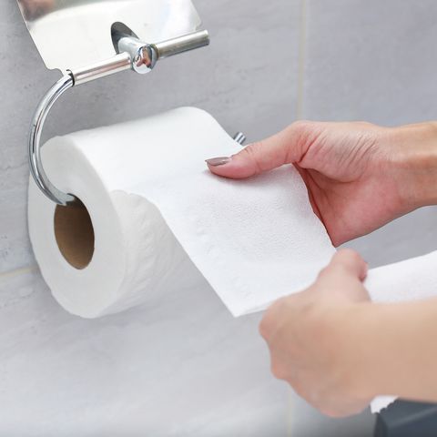 midsection of woman holding tissue paper in bathroom