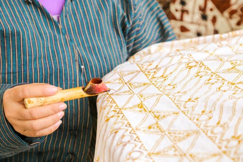 middendeel van vrouw die batik maakt op Textiel