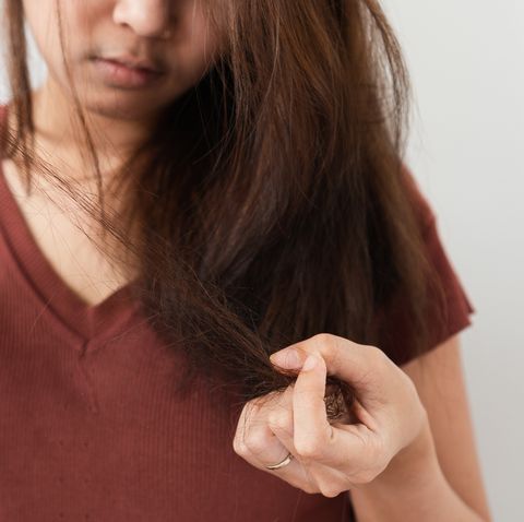 midsection of woman suffering from hair fall against gray background