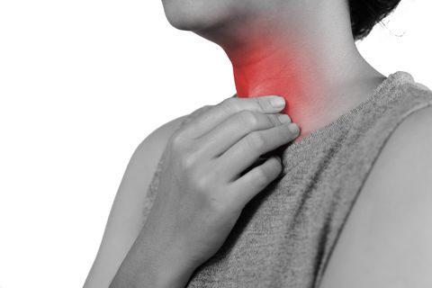 midsection of woman touching neck in pain over white background