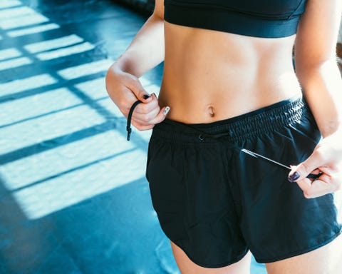 Midsection Of Woman Tying Knots Of Shorts midsection of woman tying knots of shorts