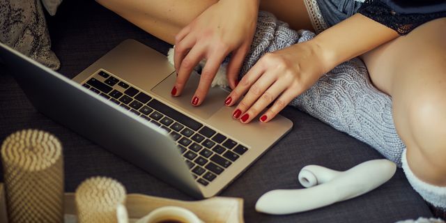 midsection of woman using laptop on sofa at home