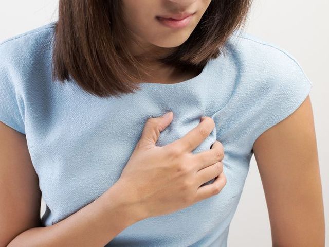 midsection of woman with chest pain against white background