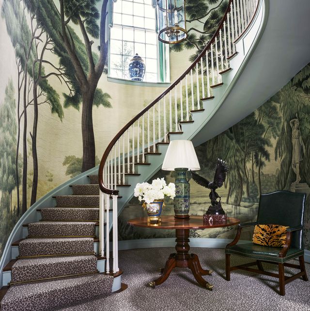 a winding staircase with a forest mural