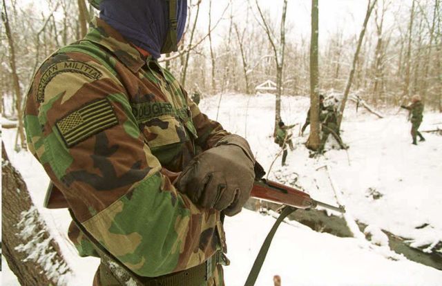 a member of the michigan militia watches as fellow survivalists train 11 december 1994  in northern michigan the leader of the michigan militia, norman olson, denies any link between his organization and the 19 april car bombing in oklahoma city, although two suspects have been reported by us television networks to have connections to the organization   afp photo photo by michael e samojeden  afp photo by michael e samojedenafp via getty images