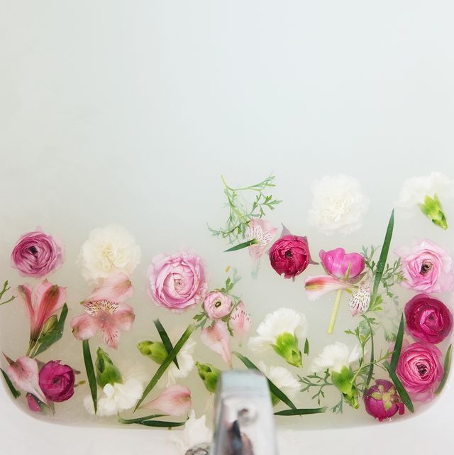 flowers floating under faucet in a milk bath