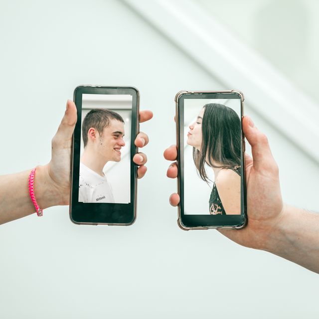 millennial couple kissing via mobile devices