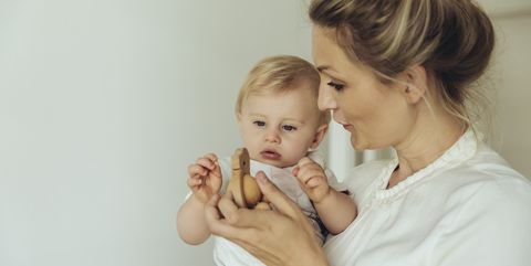 Mother showing her baby a wooden toy