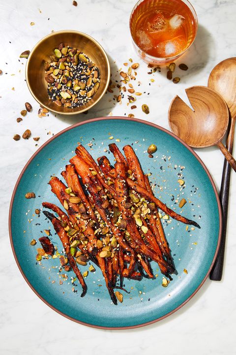 miso maple roasted carrots garnished with pistachios and sesame seeds on a teal plate