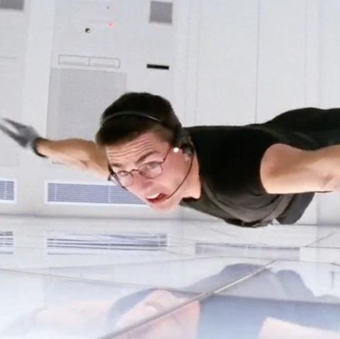 ethan hunt dangles from the ceiling during a break in heist in a scene from mission impossible it is the first film if you're watching the mission impossible movies in order