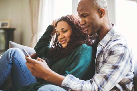 Smiling couple resting on sofa at home