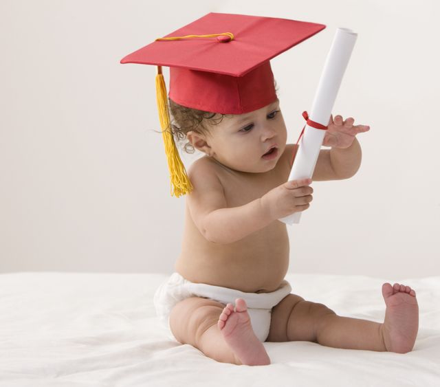 mixed race baby girl wearing mortarboard and holding a diploma