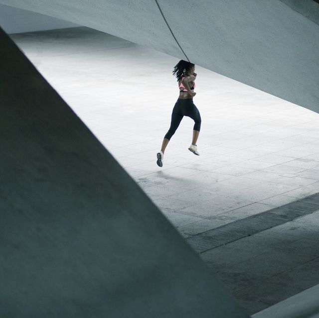 mixed race woman running under urban structure