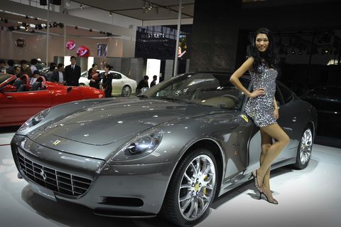 A model poses next to a Ferrari sportscar