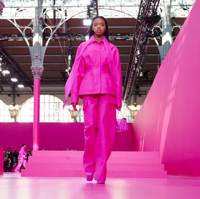 a model walks down the valentino runway wearing a hot pink matching set