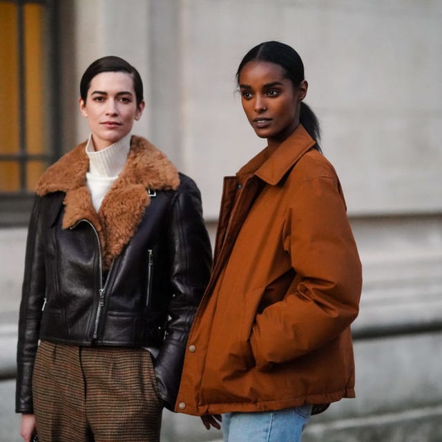 Street Style - Paris Fashion Week - Haute Couture Spring/Summer 2021 two models in fall jackets stand on a street corner in paris