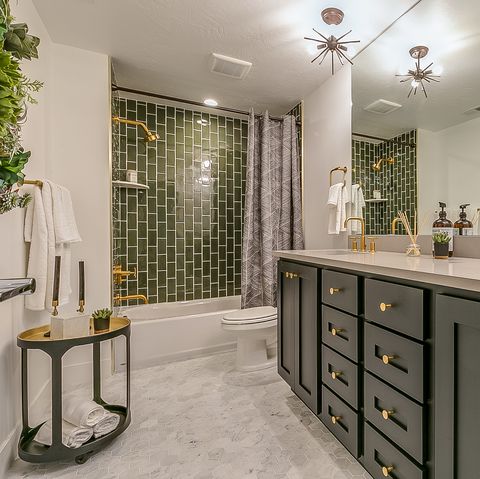 green is the theme in this beautiful bathroom with brass faucets and fixtures