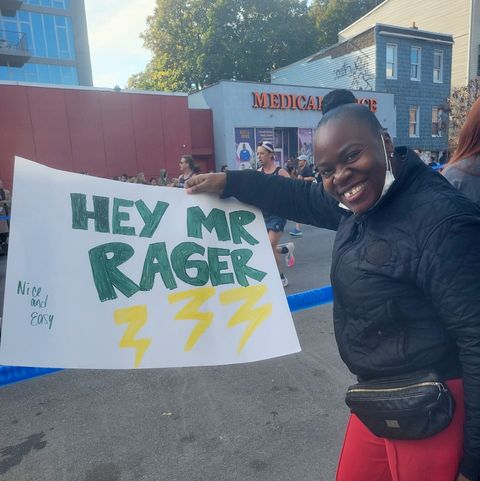 thai richard's mother, beatrice richards, holding up a sign hey mr rager at a race