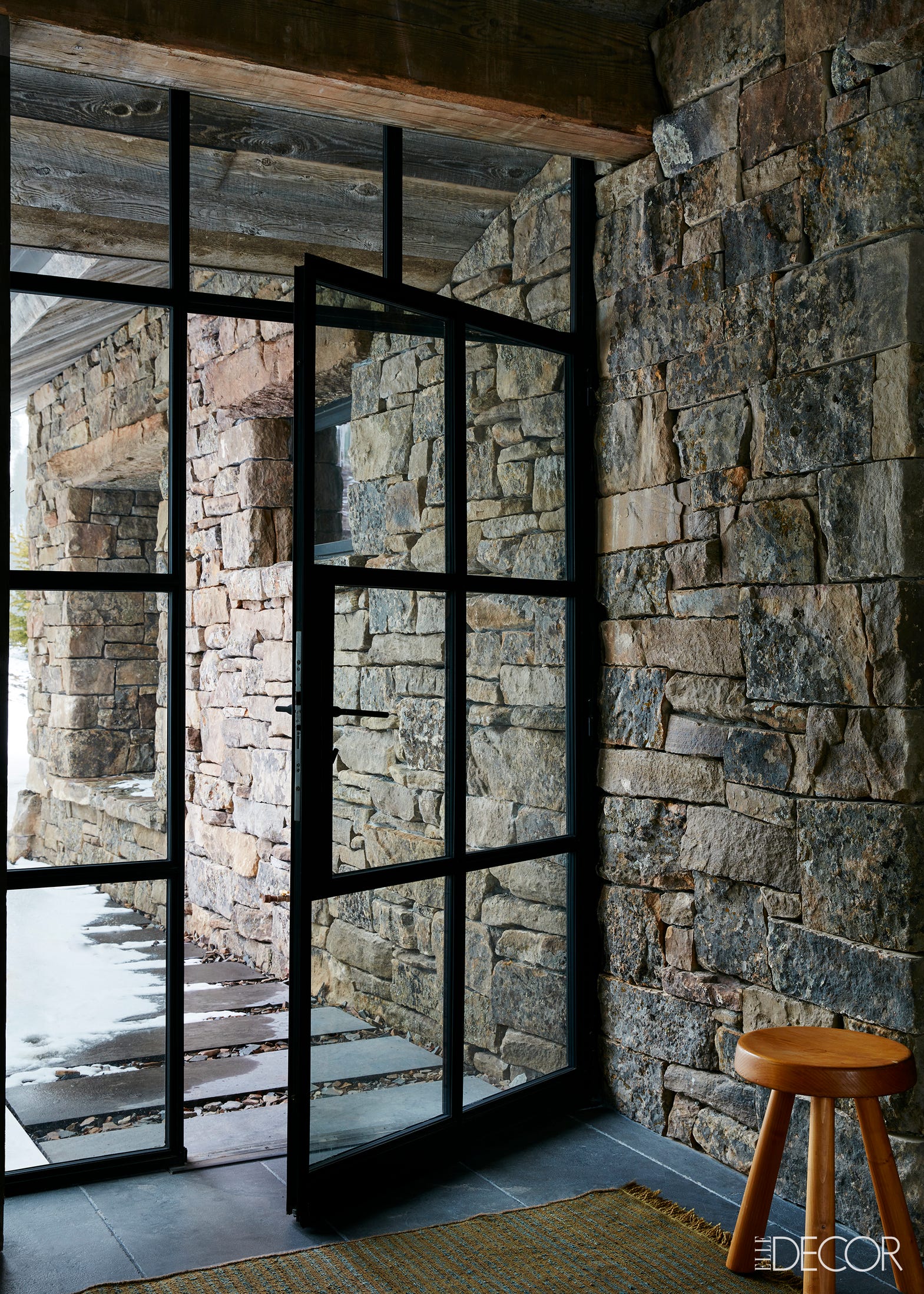 Black steel door to apres-ski room in stone Montana ski chalet on Hello Lovely