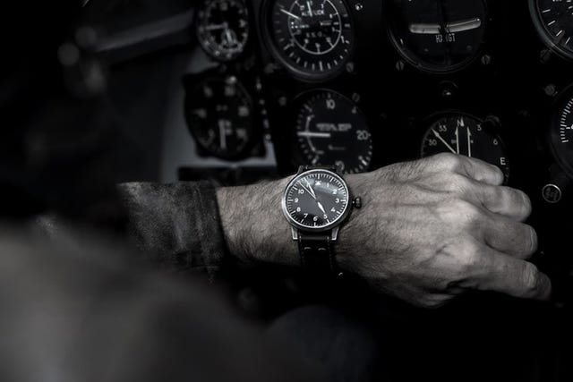 a pilot wearing a watch in a cockpit