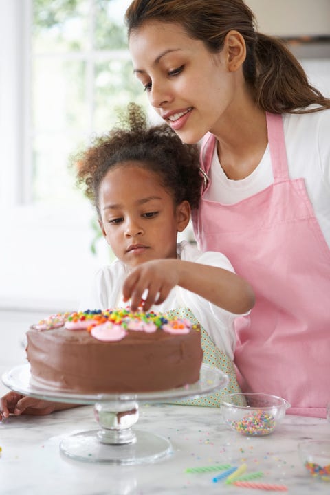 mother and daughter 3 4 decorating cake