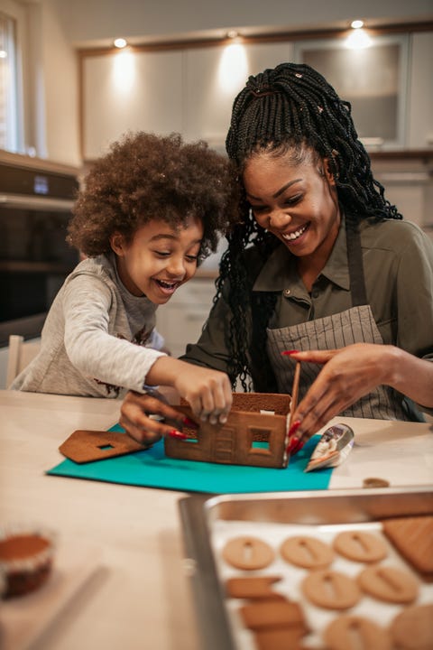 mother and her daughter assemble gingerbread house