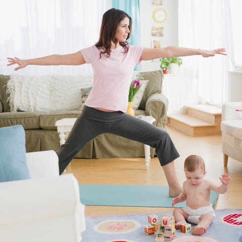 mother doing yoga, while baby plays