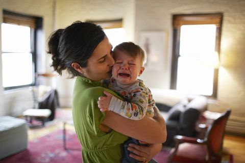 madre con bebé en brazos llorando y dándole besos