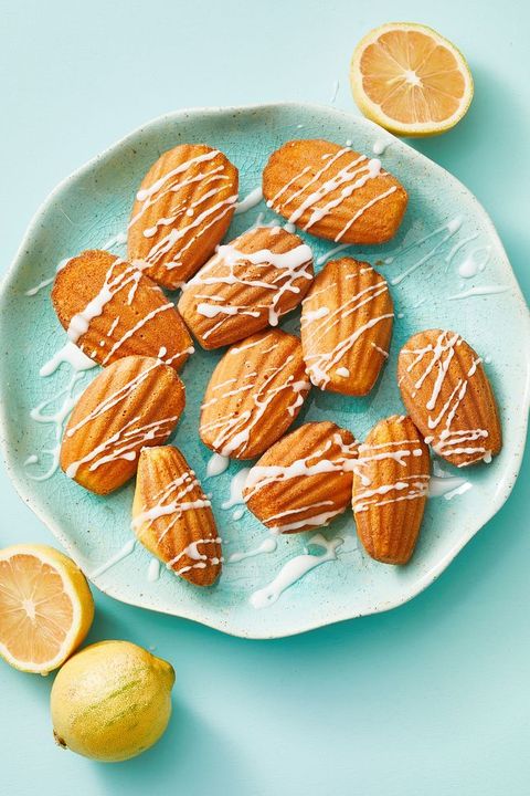 meyer lemon madeleines with icing drizzled on a blue plate