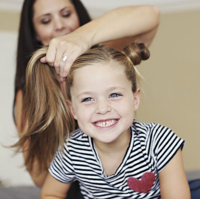 madre haciendo un peinado a su hija