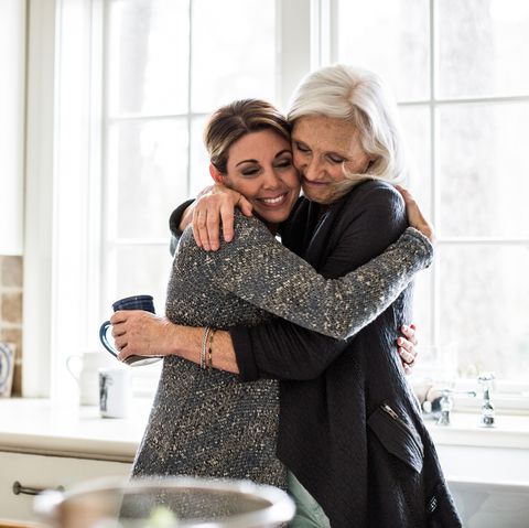 mother and daughter hugging in kitchen