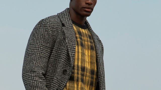 model wearing a yellow sweater and grey overcoat